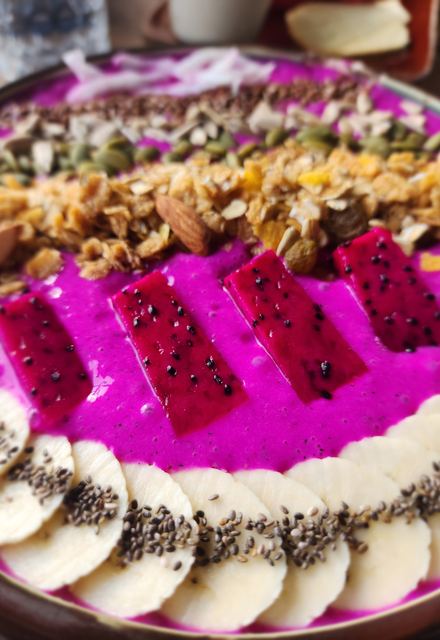 A dragon fruit smoothie bowl with granola and banana